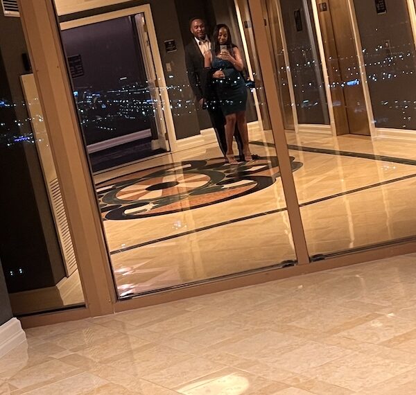 Black couple dressed in formal attire in Four Seasons elevator heading to fine dining